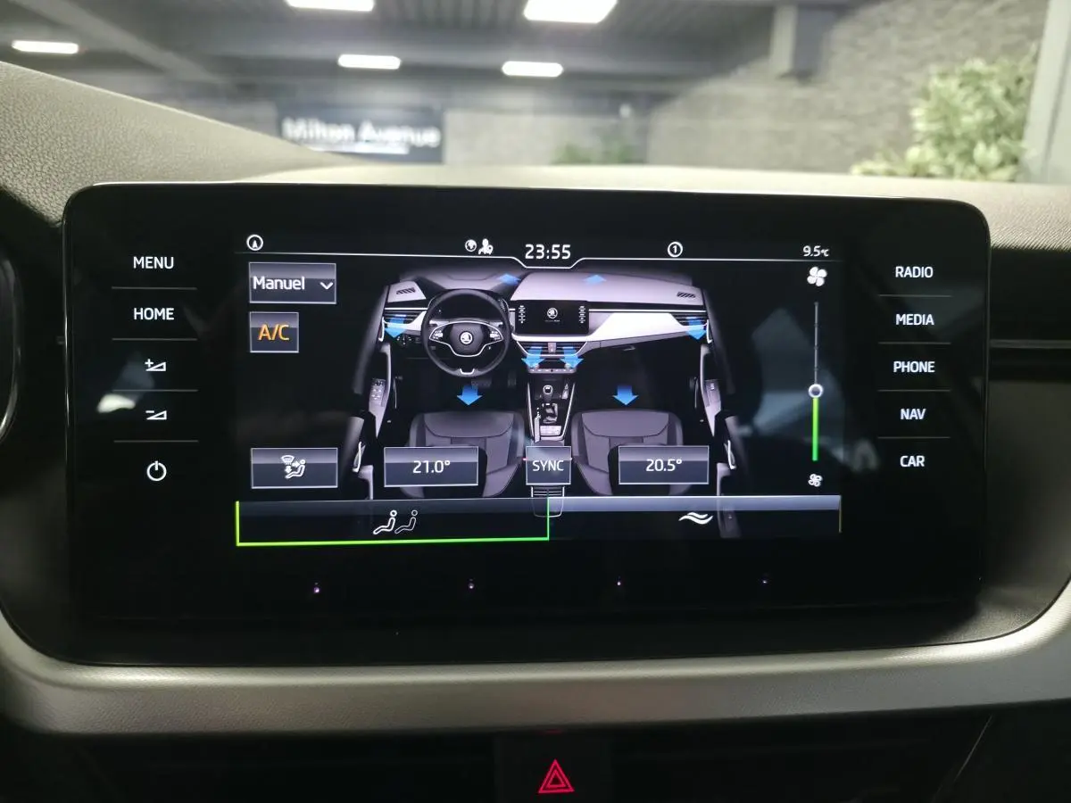 Écran tactile central du Skoda Kamiq 2023 affichant la climatisation bi-zone avec vue intérieure stylisée.