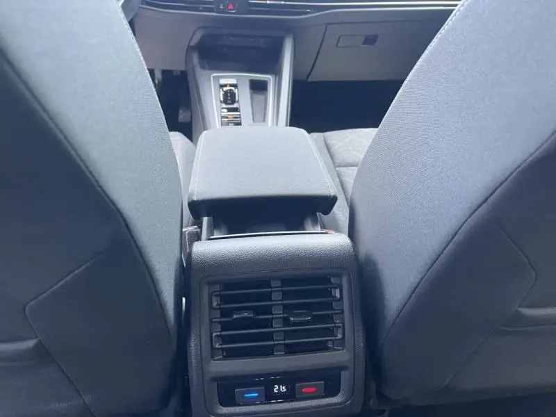 Vue intérieure arrière centrée sur la console centrale et les aérateurs arrière d'une Volkswagen Golf 1.5 eTSI gris Urano