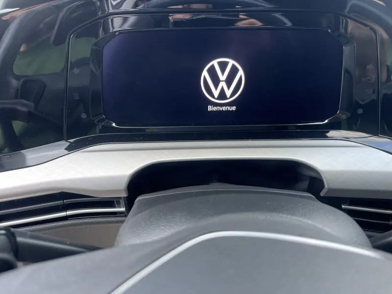 Vue rapprochée du tableau de bord de la Volkswagen Golf 1.5 eTSI, écran digital affichant le logo VW et "Bienvenue".