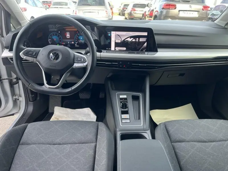 Vue intérieure avant de la Volkswagen Golf 1.5 eTSI Life Business 2020, tableau de bord moderne avec écran tactile et volant multifonction noir.