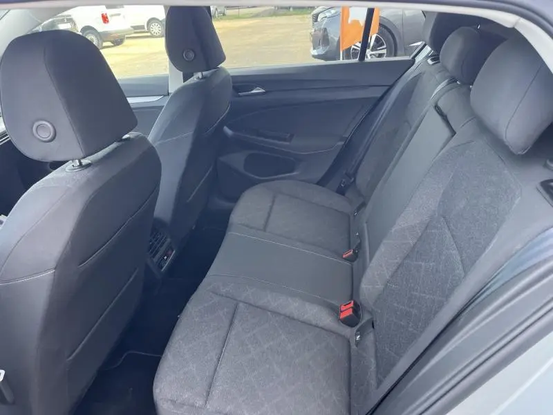 Vue intérieure arrière de la Volkswagen Golf 1.5 eTSI Life Business 2020, sièges tissu gris foncé et appuie-têtes.