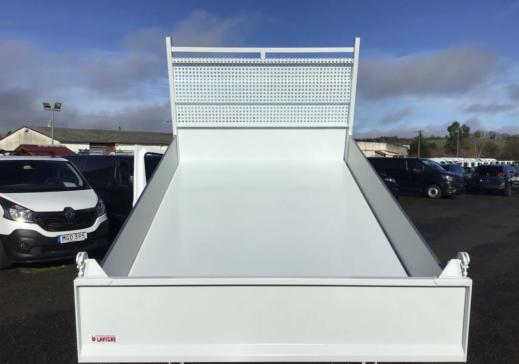 Vue arrière frontale d'une benne blanche Ford Transit Chassis Cabine L2 T350 2024, plateau vide et grillage de protection.