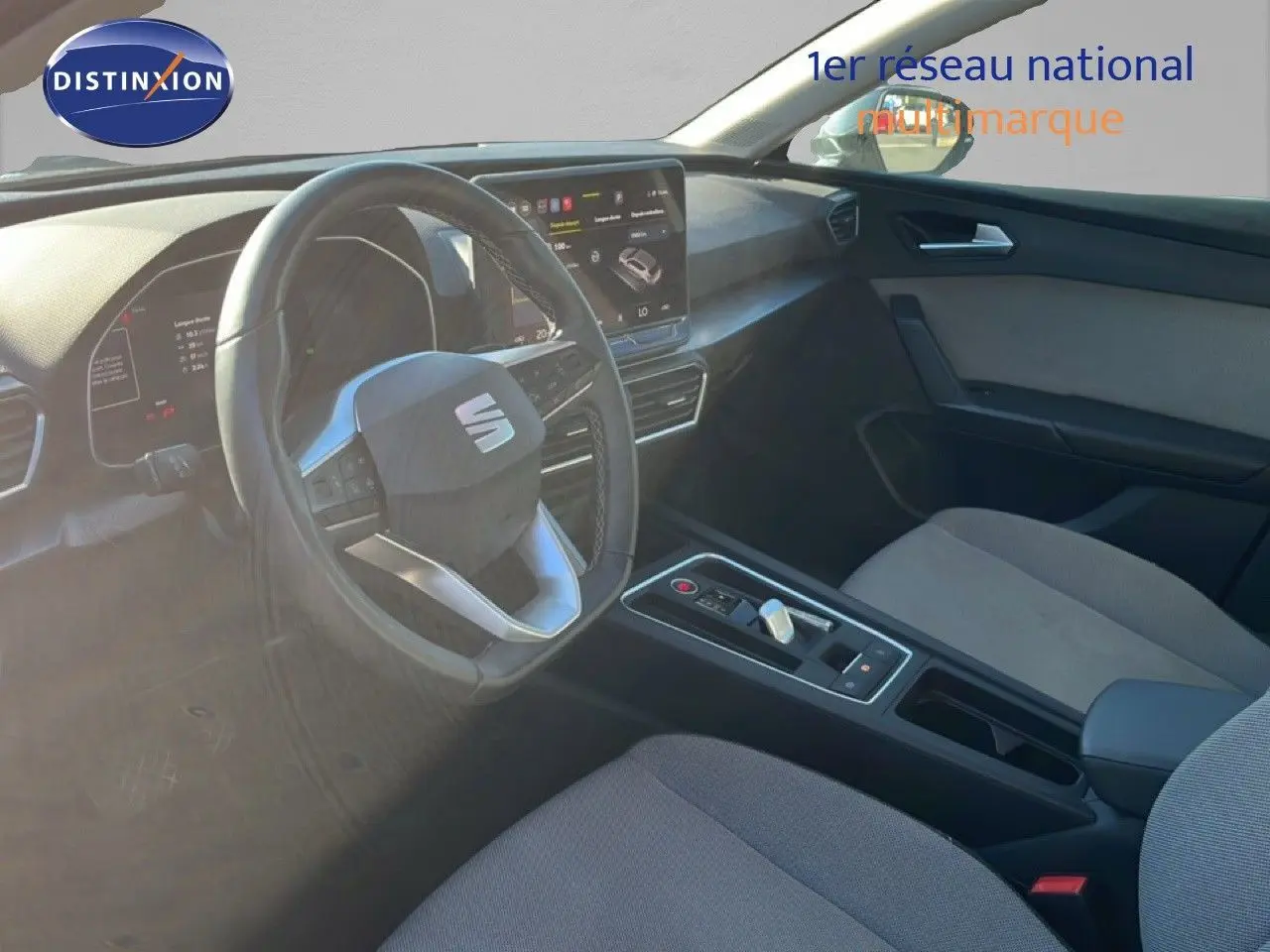 Vue intérieure côté conducteur de la SEAT LEON 2025, mettant en valeur le volant multifonction et la console centrale moderne.