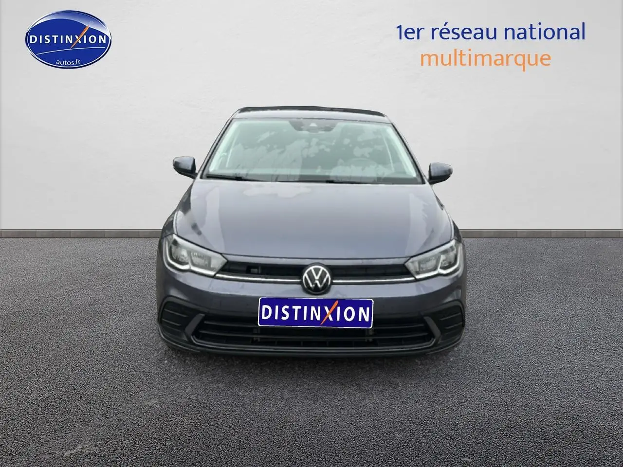 Vue frontale d'une Volkswagen Polo gris cendre 2025 avec calandre noire et phares LED allumés.