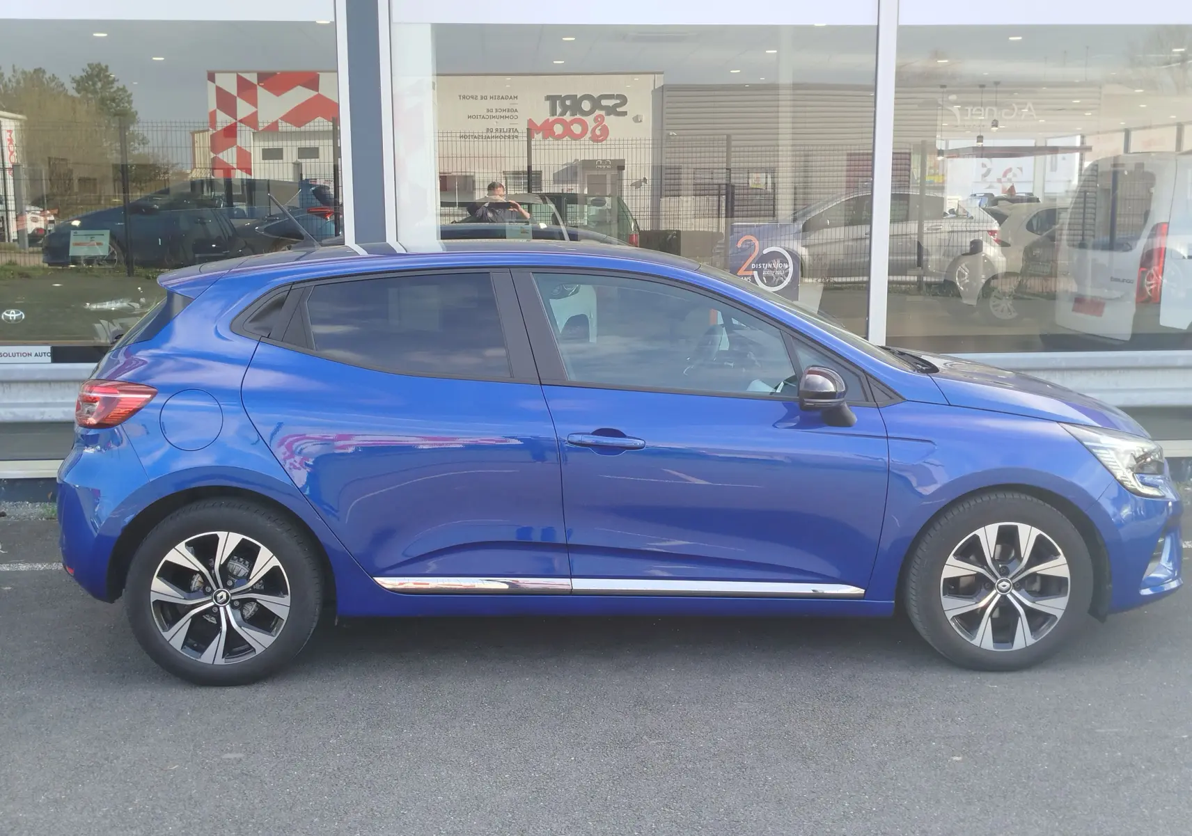 Profil droit d'une Renault Clio 1.0 SCe 65ch Evolution 2022 en Bleu Iron avec jantes alliage et vitres teintées.