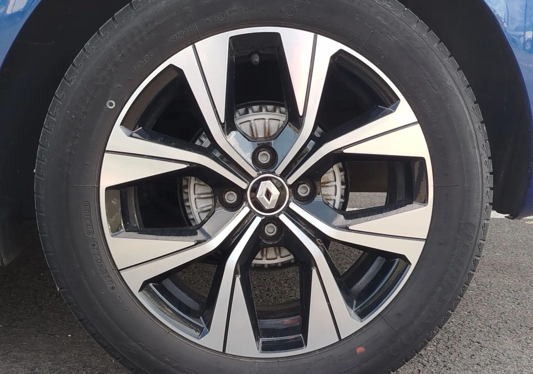 Gros plan sur la jante alliage bicolore noire et argentée d’une Renault Clio Bleu Iron 2022.