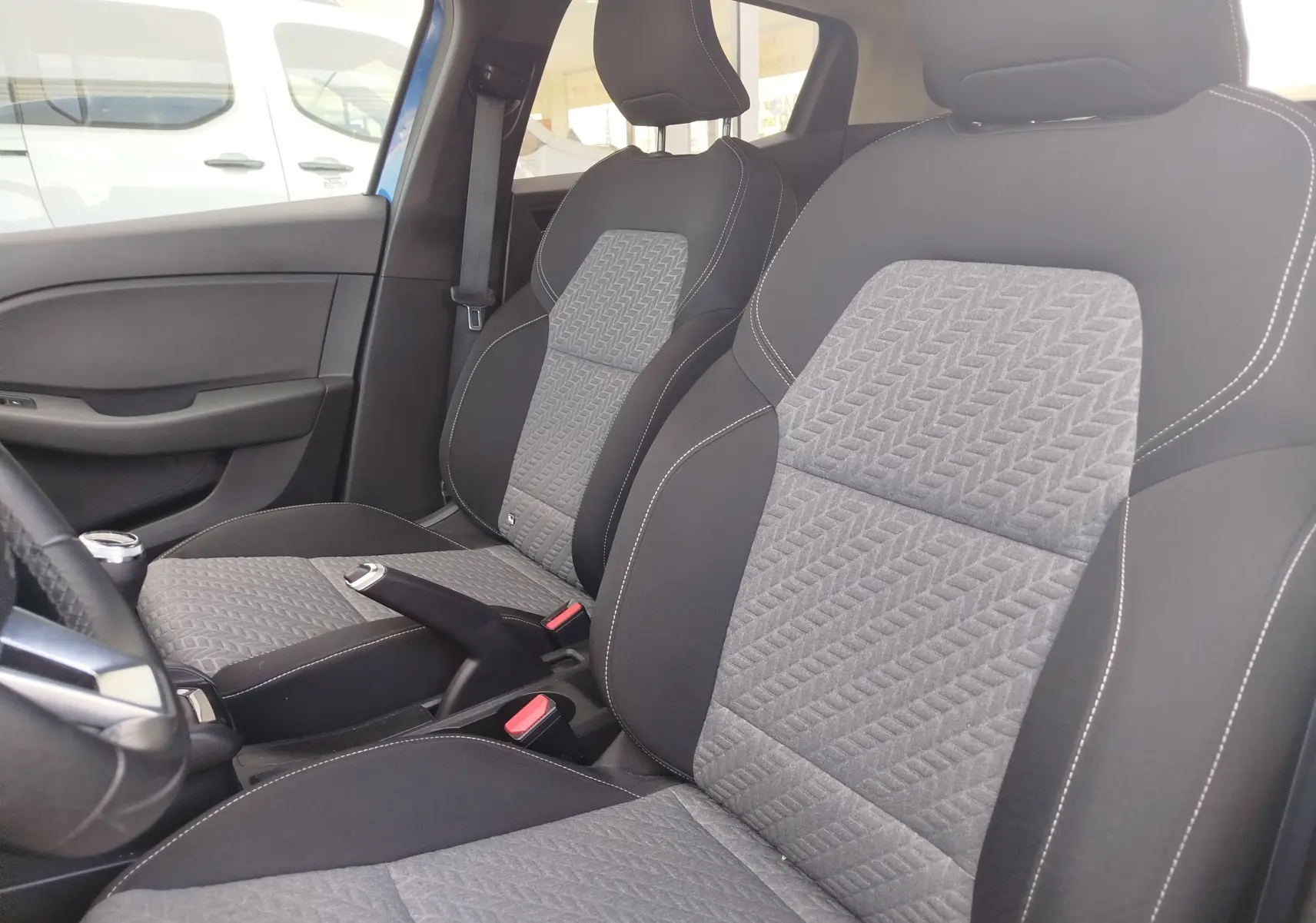 Vue intérieure rapprochée des sièges avant gris et noirs de la Renault Clio 1.0 SCe 65ch Evolution 2022.