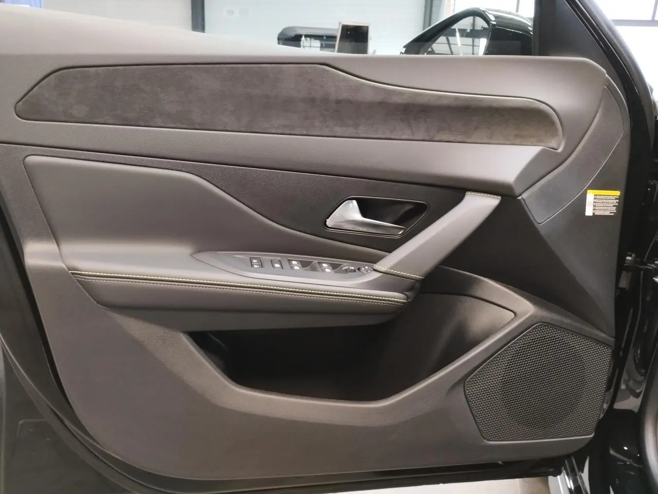 Vue intérieure côté gauche de la porte avant noire métallisée du Peugeot 308 avec garniture en similicuir et alcantara.