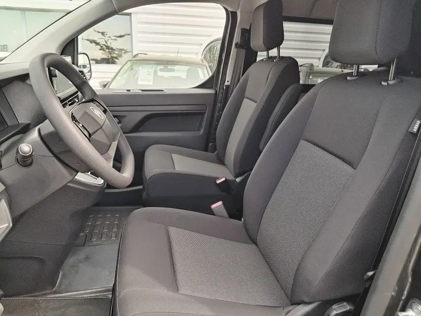 Vue intérieure côté conducteur du Citroën Jumpy Cabine Approfondie gris titane, sièges noirs avec accoudoir passager.