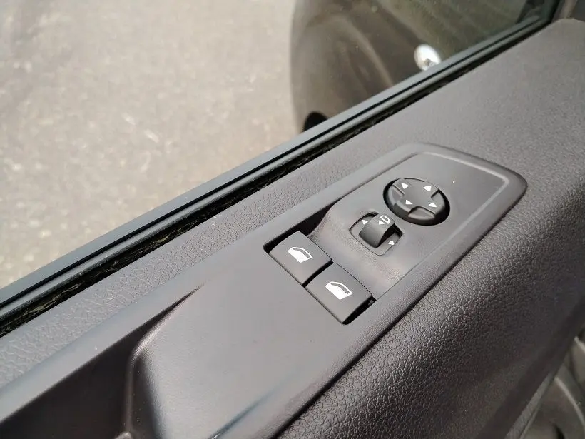 Gros plan sur les commandes électriques des vitres et rétroviseurs côté conducteur du Citroën Jumpy Cabine Approfondie gris titane.