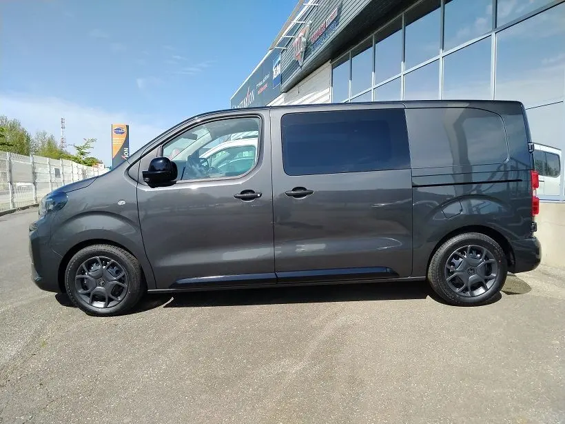Vue de profil côté gauche d’un Citroën Jumpy Cabine Approfondie gris titane avec portes latérales coulissantes et roues tôlées noires.