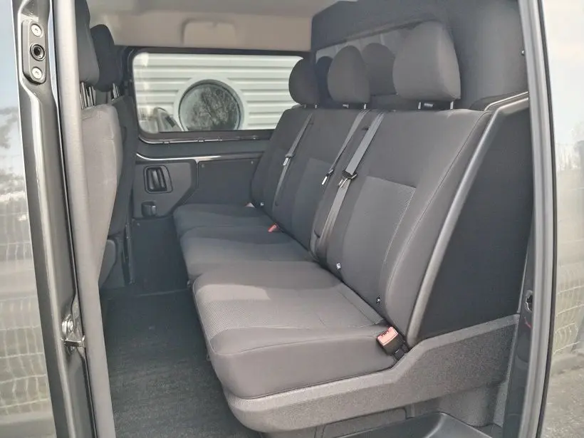 Vue intérieure côté droit des sièges arrière gris foncé du Citroën Jumpy Cabine Approfondie 2025 avec ceintures de sécurité.