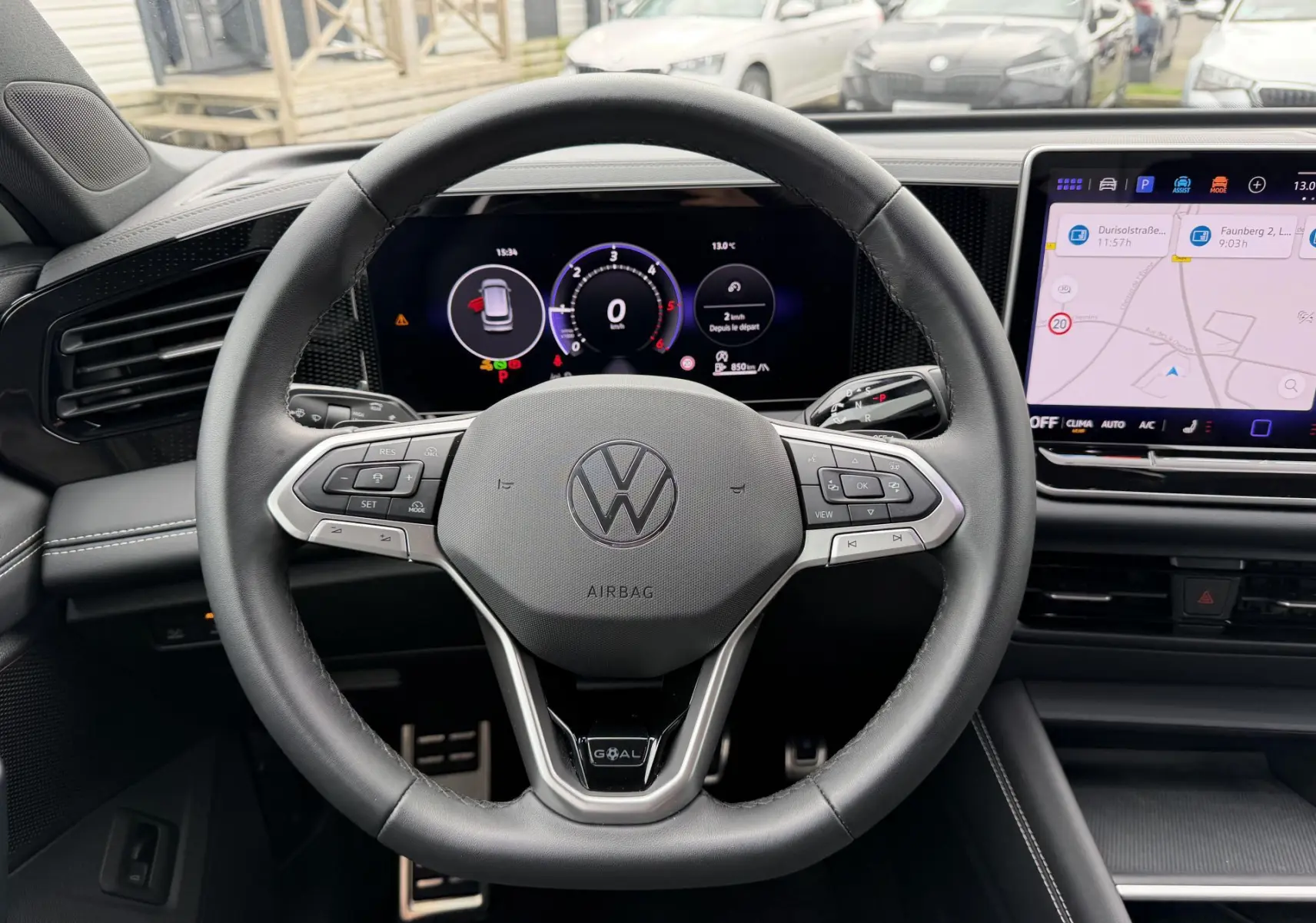 Vue intérieure centrée sur le volant cuir multifonction et l'écran numérique du Volkswagen Tiguan blanc 2025.