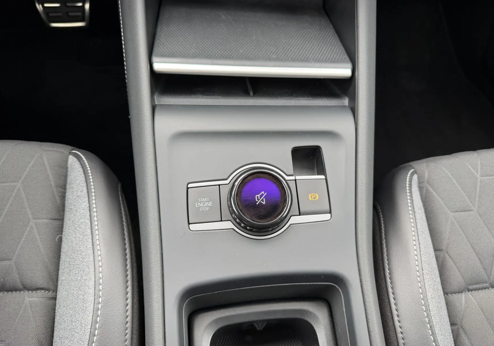 Vue rapprochée du console central du Volkswagen Tiguan 2025 montrant la molette de commande et les sièges gris.