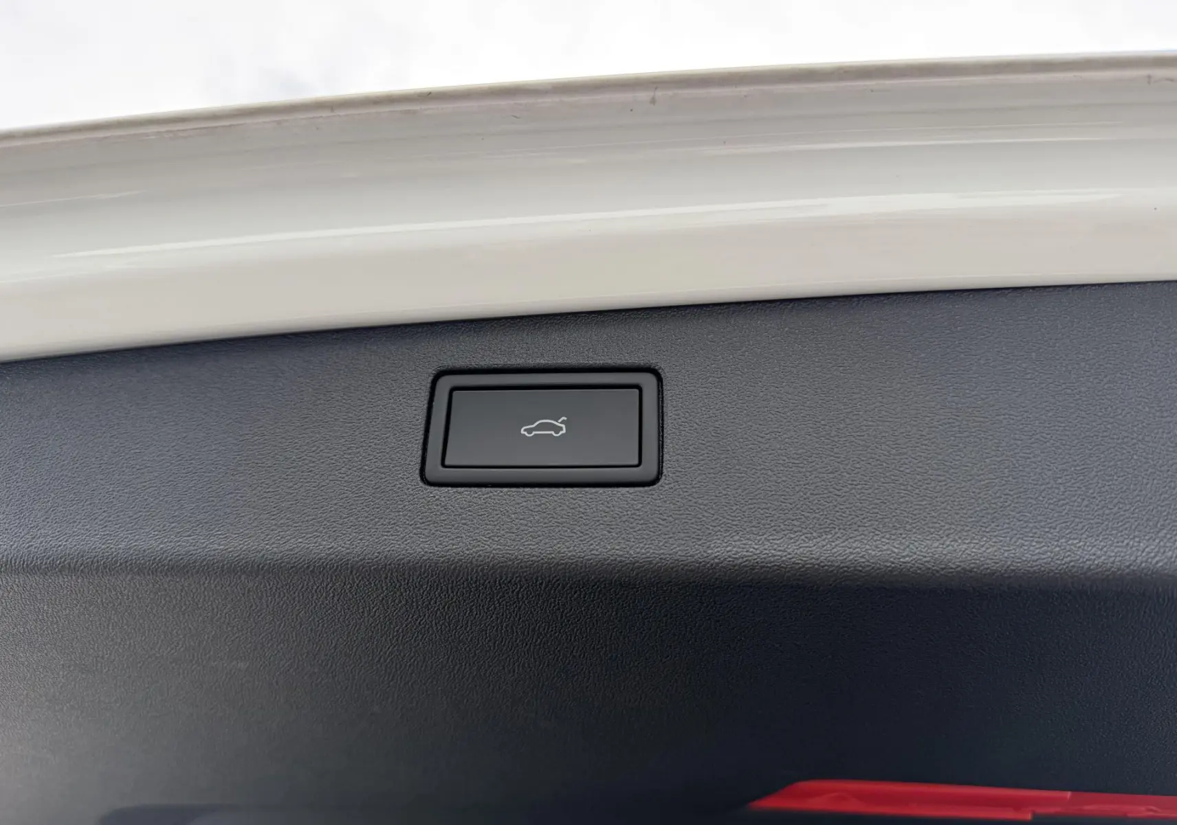 Bouton d'ouverture électrique du hayon sur le bord intérieur blanc d'un Volkswagen Tiguan 2025.