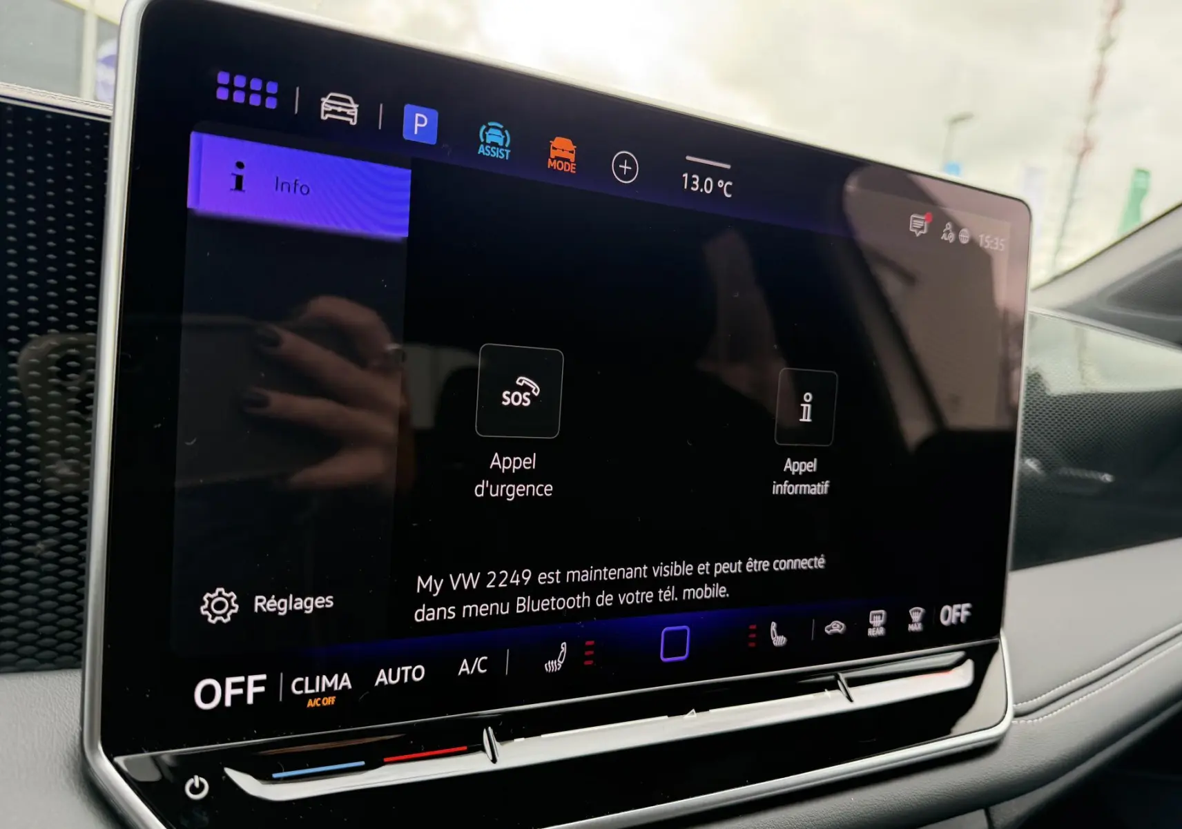 Écran tactile central du Volkswagen Tiguan 2025 montrant les options d'appel d'urgence et réglages, intérieur gris.