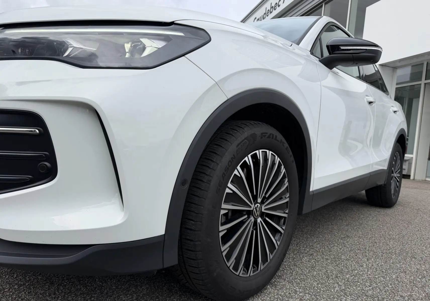 Vue en 3/4 avant droit d’un Volkswagen Tiguan blanc, mettant en valeur le phare Matrix HD et la jante alliage distinctive.