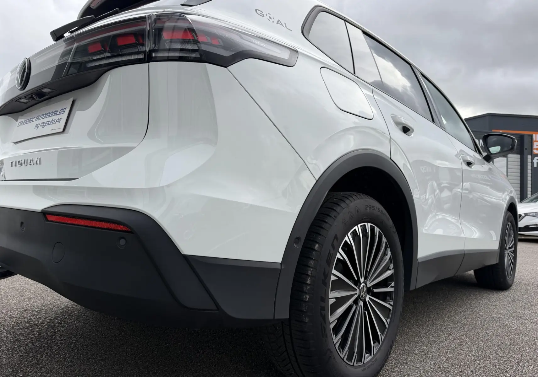 Vue 3/4 arrière droite du Volkswagen Tiguan blanc 2025, avec jantes alliage et feux arrière LED distinctifs.