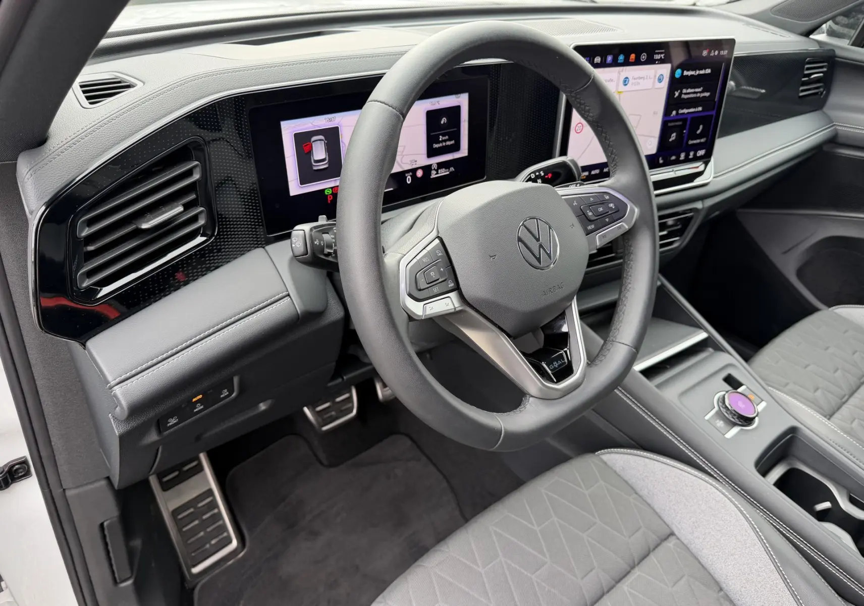 Vue intérieure côté conducteur du Volkswagen Tiguan 2025, volant cuir multifonction et écran tactile digital.
