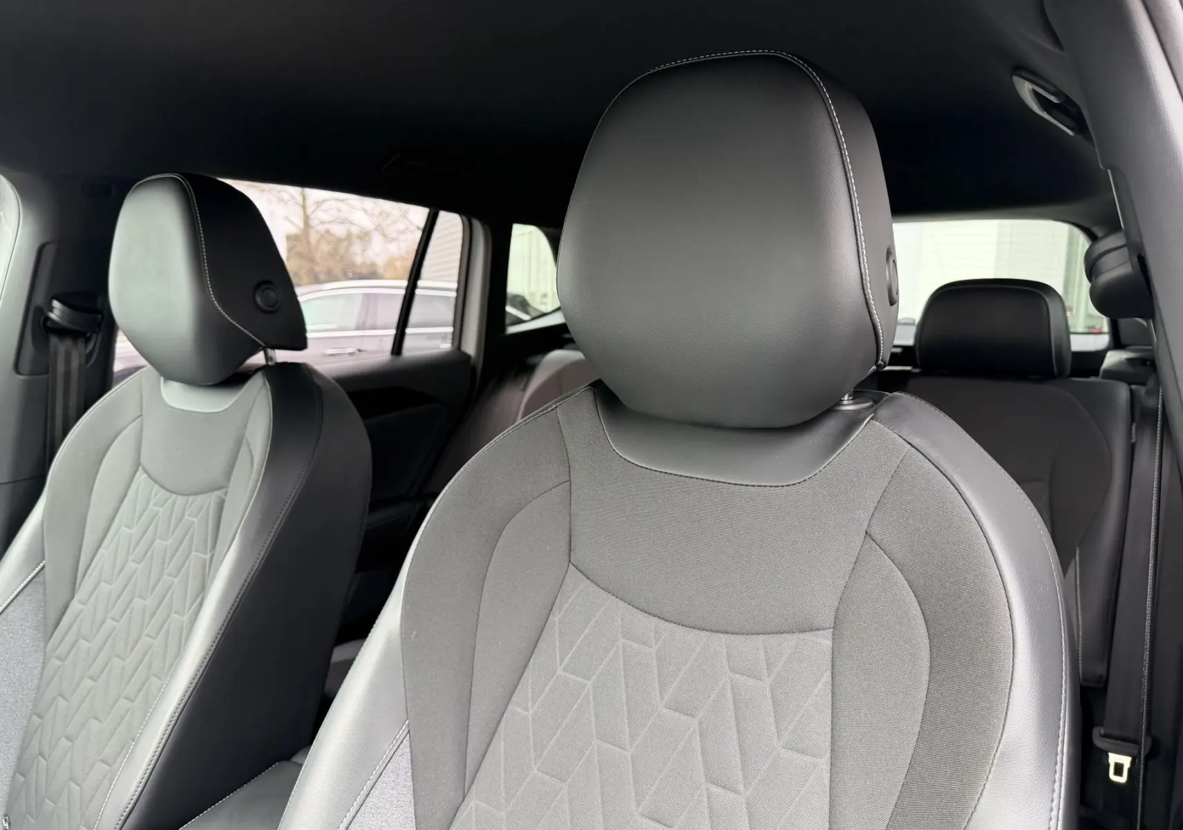 Gros plan sur les sièges avant gris du Volkswagen Tiguan 2025, vue intérieure côté droit avec appuie-tête en cuir.