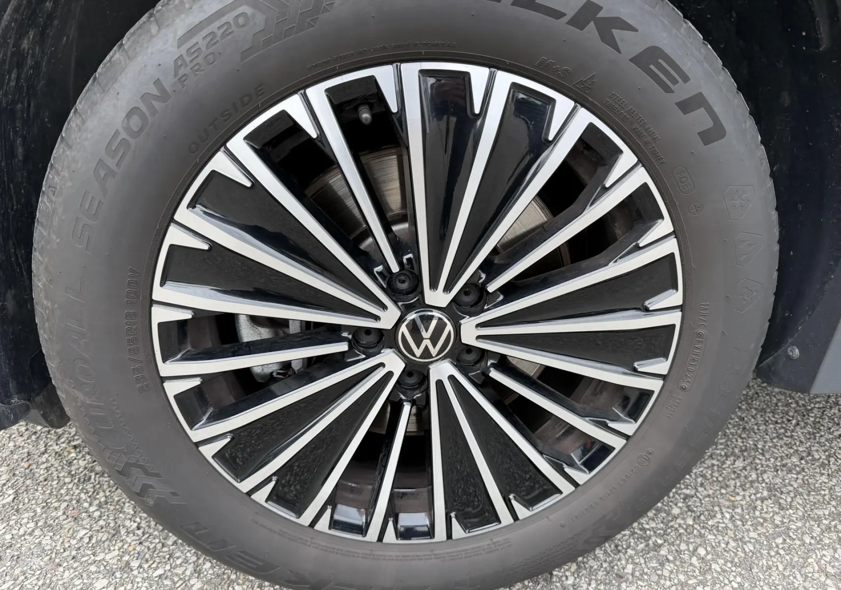 Gros plan sur la jante noire et argentée d’un Volkswagen Tiguan 2025 avec logo VW au centre et pneu Falken.