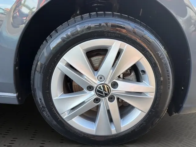Gros plan sur la roue avant droite grise d'une Volkswagen Golf 2023 avec jante alliage et logo VW au centre.