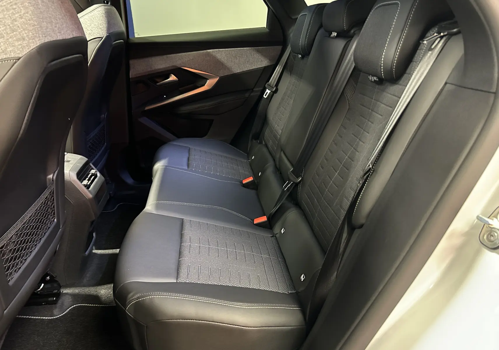 Vue latérale droite de la banquette arrière noire avec surpiqûres blanches du Peugeot 3008 III Hybrid 2026.