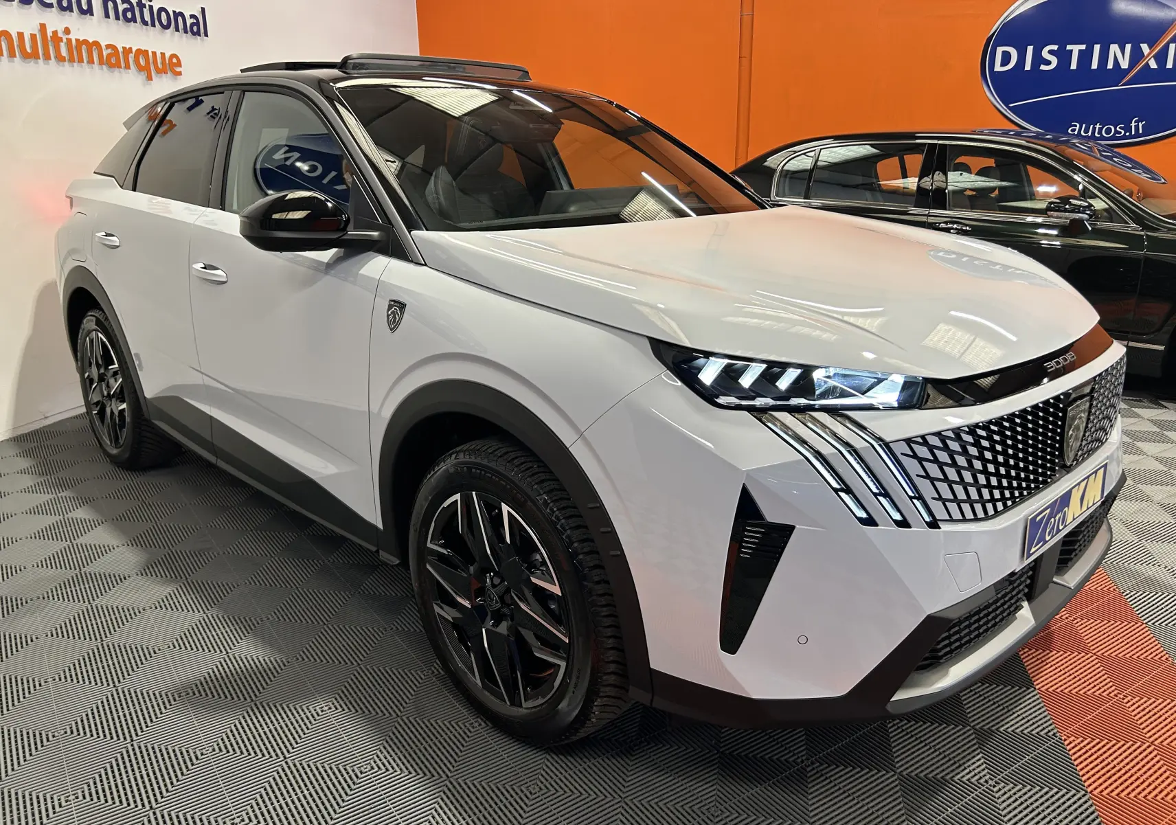 Peugeot 3008 Hybrid blanc Okenite en 3/4 avant droit, avec calandre distinctive et phares LED allumés.