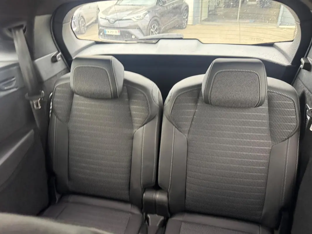 Vue intérieure arrière montrant les deux sièges noirs du Peugeot 5008 Hybrid 145 ch e-DCS6 GT 2025.