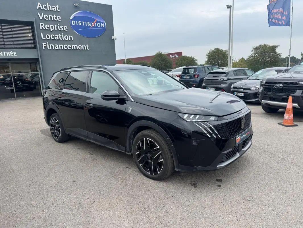 Peugeot 5008 Hybrid noir vue 3/4 avant gauche, avec jantes alliage noires et barres de toit visibles.