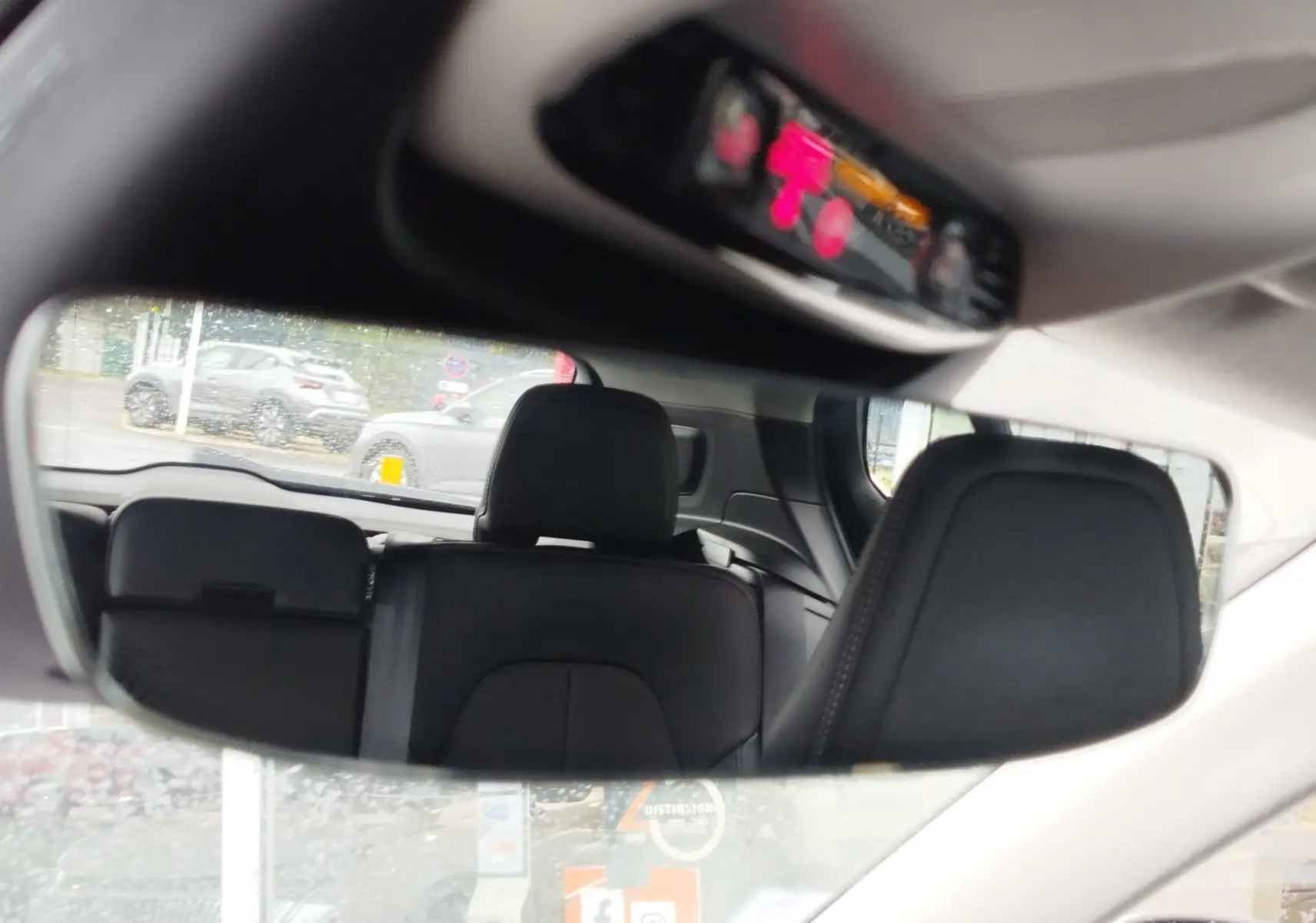 Reflet dans le rétroviseur intérieur montrant les sièges arrière en cuir noir du Volvo XC40 beige de 2020.
