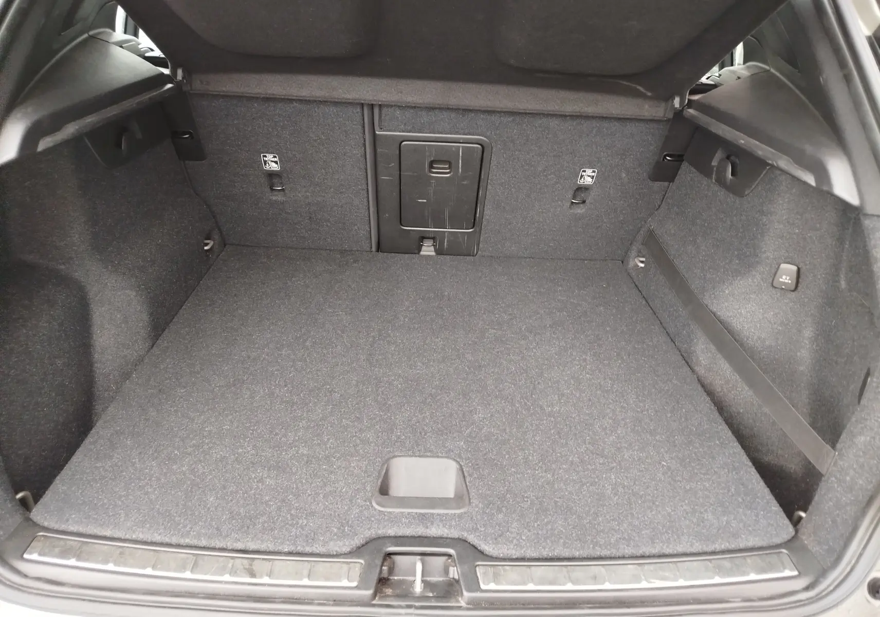 Coffre ouvert du Volvo XC40 beige 2020, vue de l'arrière montrant un espace de chargement propre et bien agencé.