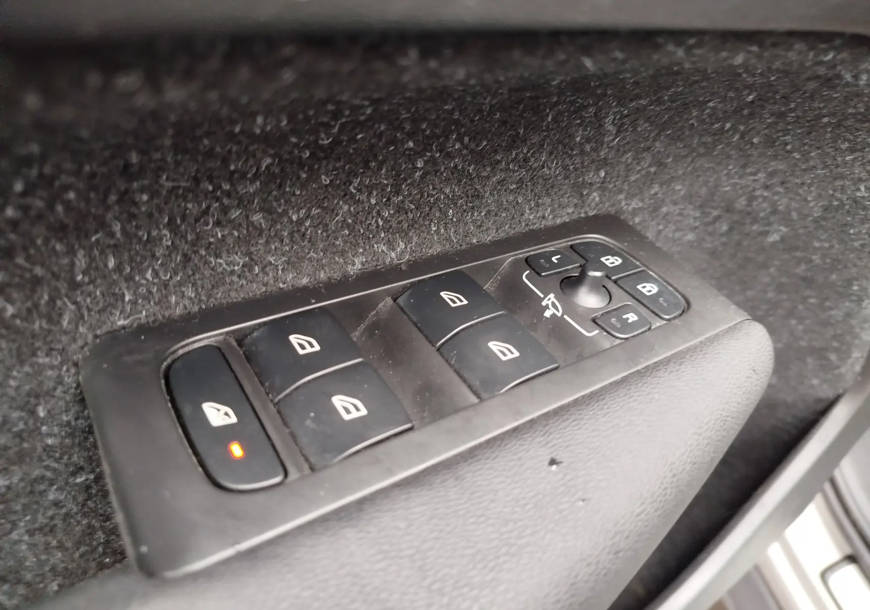Gros plan sur les commandes des vitres et rétroviseurs côté conducteur du Volvo XC40 beige de 2020.