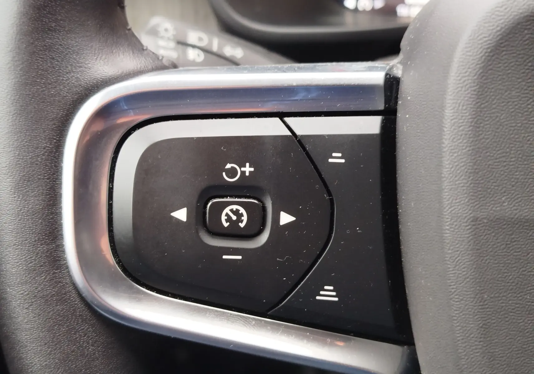 Gros plan sur les commandes de régulateur de vitesse au volant d’un Volvo XC40 beige, version D3 2020.