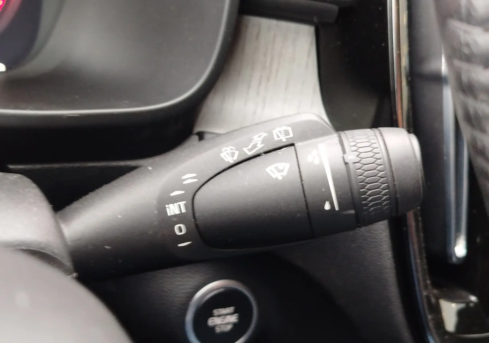 Gros plan sur la commande d’essuie-glace du Volvo XC40 beige, avec bouton start/stop en arrière-plan.