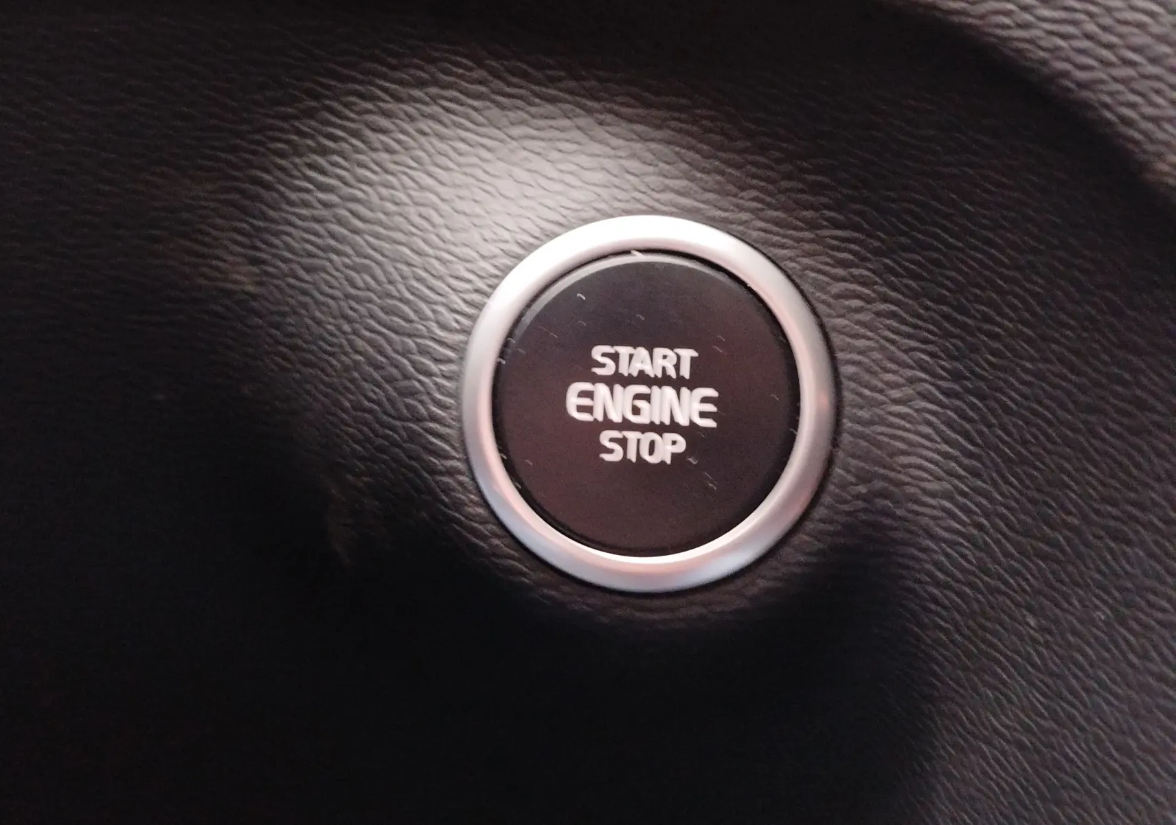 Bouton rond noir "Start Engine Stop" sur tableau de bord en cuir noir du Volvo XC40 beige 2020.