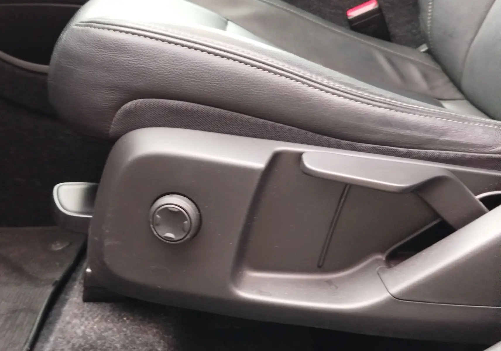 Gros plan sur la commande de réglage du siège conducteur en cuir noir du Volvo XC40 beige, version D3 2020.
