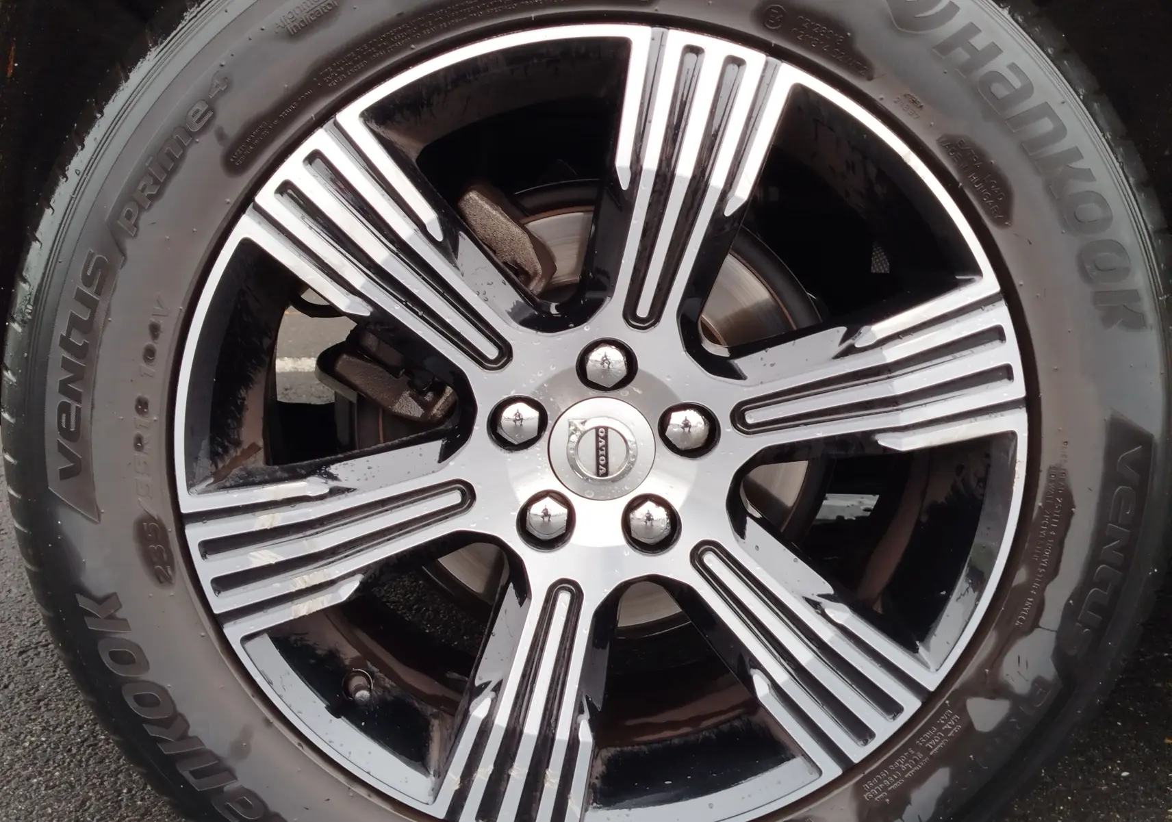 Gros plan sur la jante alliage bicolore noire et argentée d’un Volvo XC40 beige, avec pneu Hankook Ventus Prime 4.
