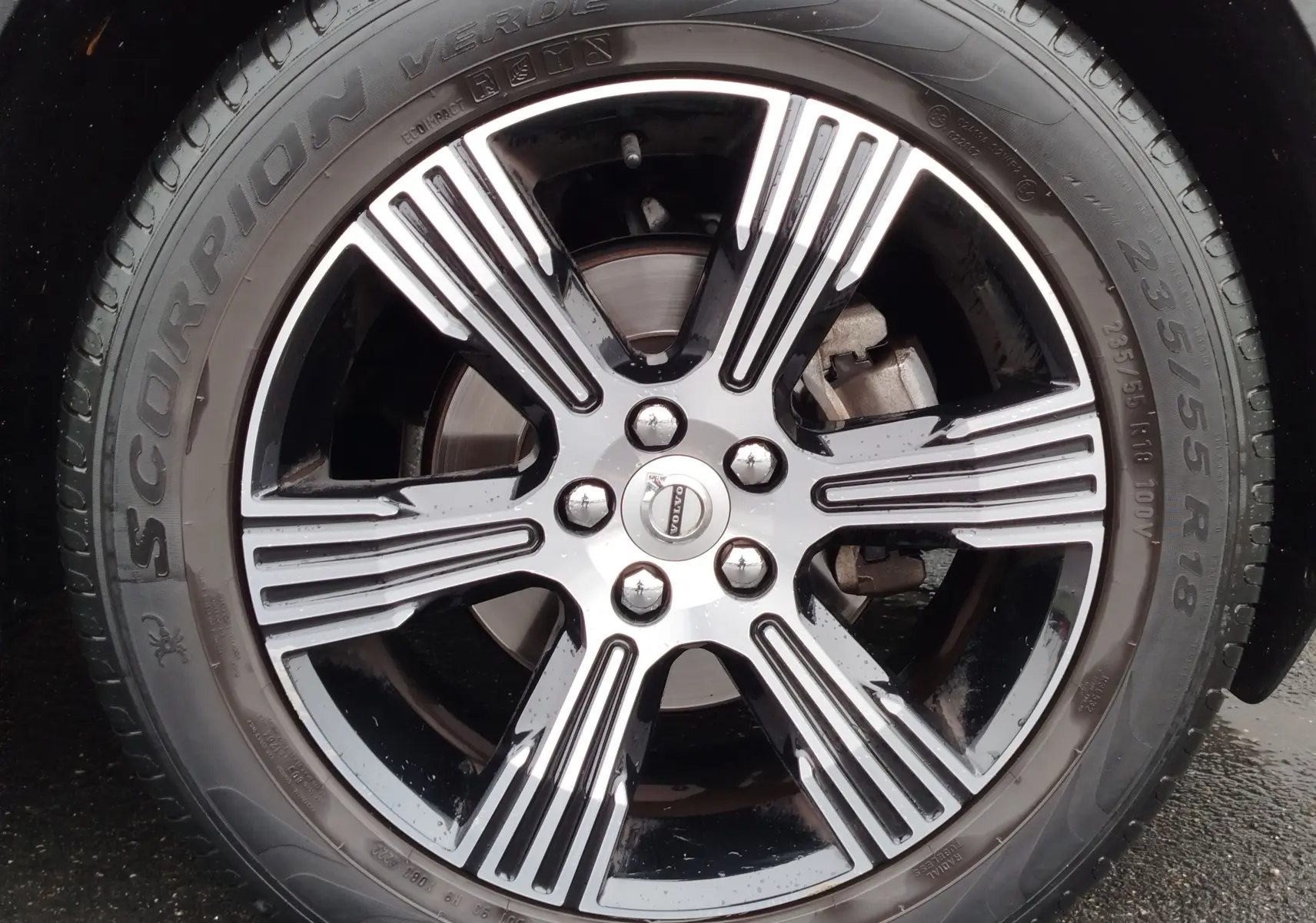 Gros plan sur la jante bi-ton noire et argentée d’un Volvo XC40 beige, avec pneu Pirelli Scorpion Verde.