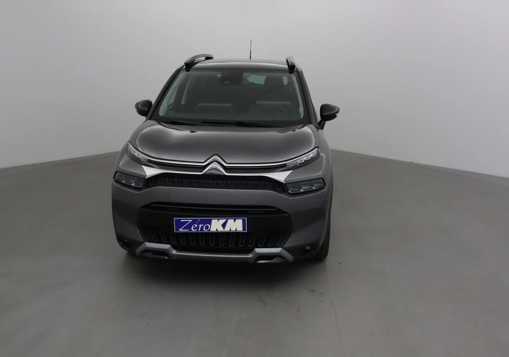Citroën C3 Aircross 2024 gris platinium vue de face avec calandre distinctive et toit noir contrasté.