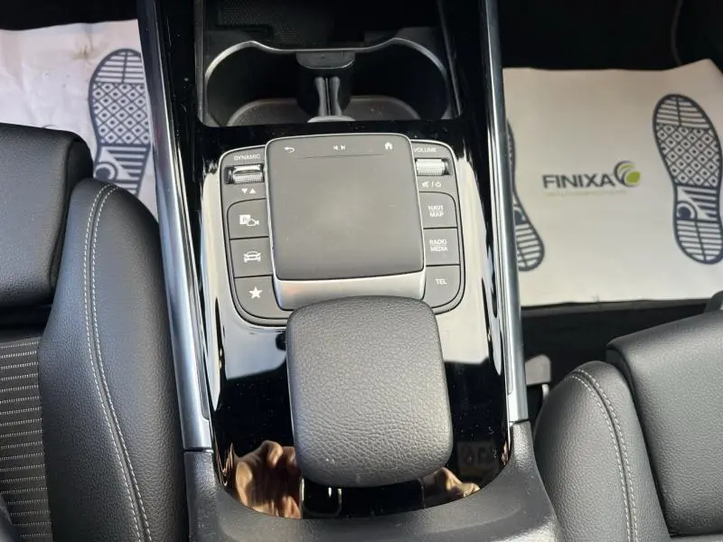 Vue rapprochée de la console centrale noire avec pavé tactile et accoudoir en similicuir noir du Mercedes GLA 200 Business Line.
