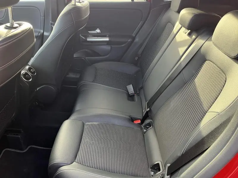 Vue latérale intérieure montrant la banquette arrière en tissu noir du Mercedes GLA 200 rouge Patagonie métallisé designo.