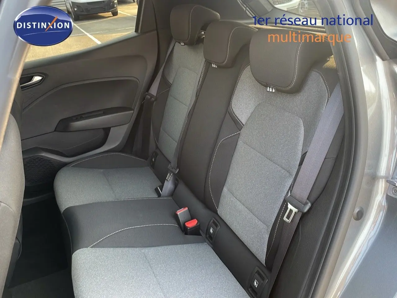 Vue intérieure arrière montrant la banquette arrière gris clair et noir de la Renault Clio 2025, porte ouverte côté droit.