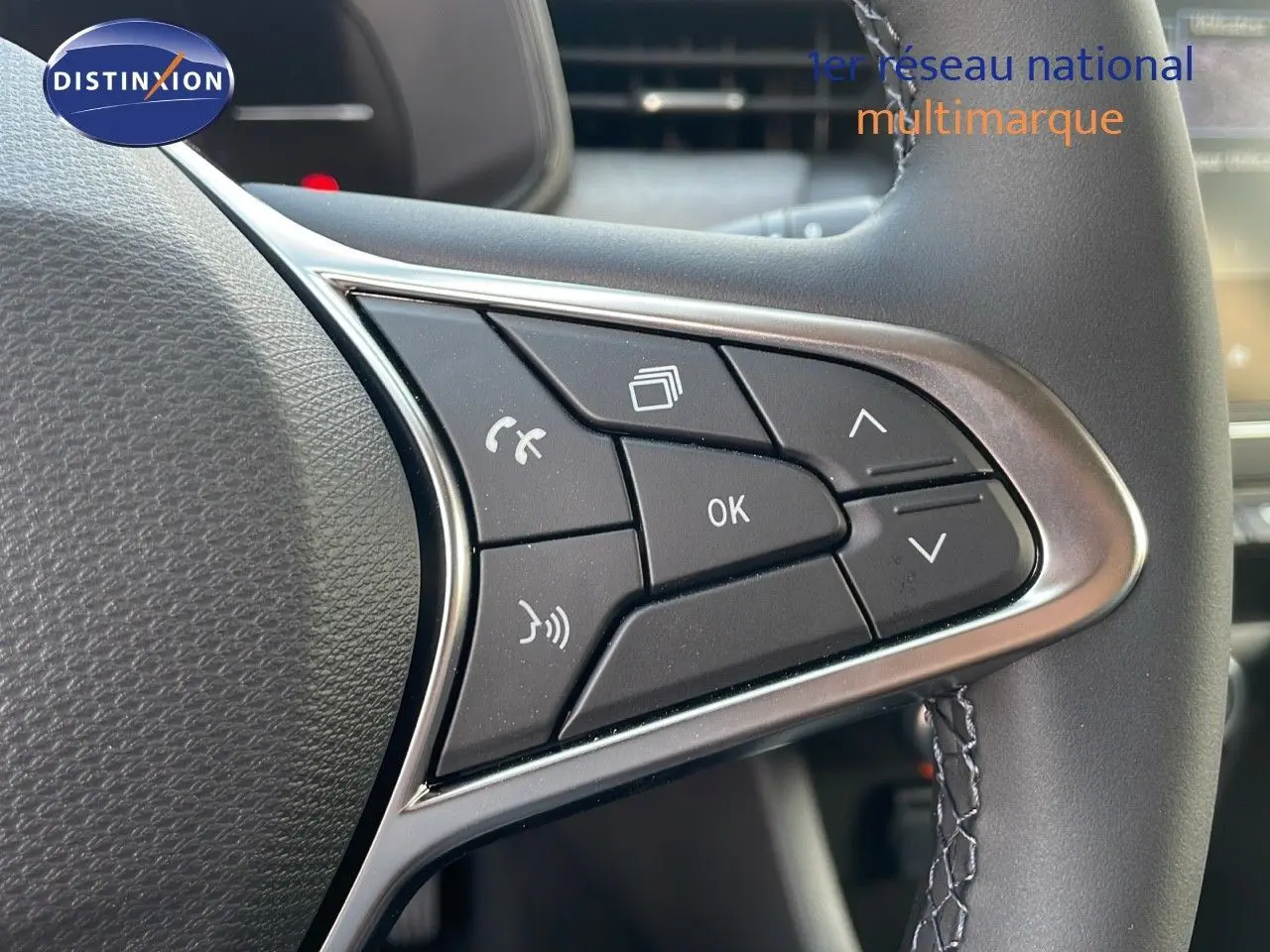 Gros plan sur les commandes multifonctions au volant de la Renault Clio gris schiste métal, version 2025.