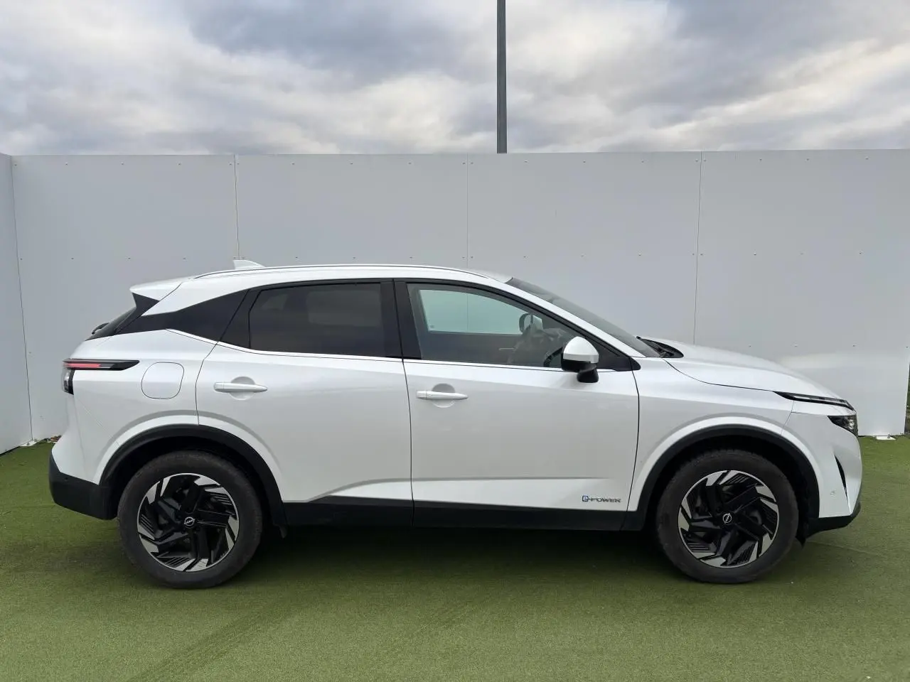 Vue profil droit du Nissan Qashqai III blanc nacré avec jantes alliage noires et toit contrasté noir.