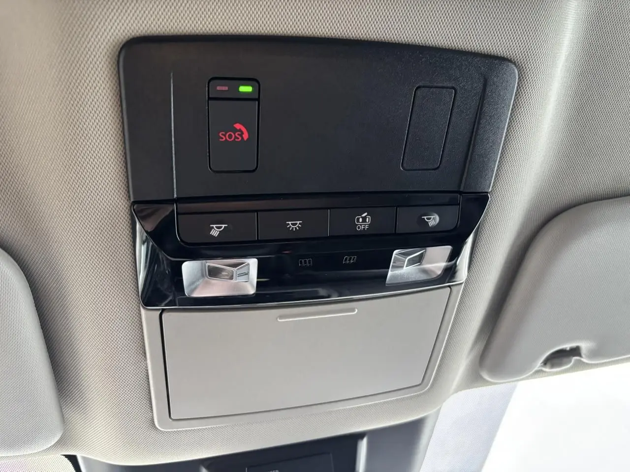 Vue en gros plan du plafonnier intérieur noir et gris du Nissan Qashqai blanc nacré avec boutons SOS et éclairage LED.