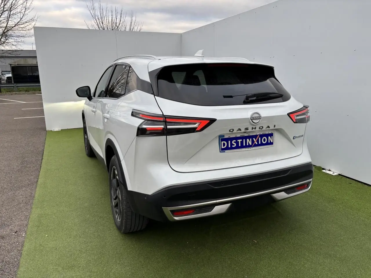 Vue 3/4 arrière d'un Nissan Qashqai blanc nacré avec feux LED et toit avec antenne aileron de requin.