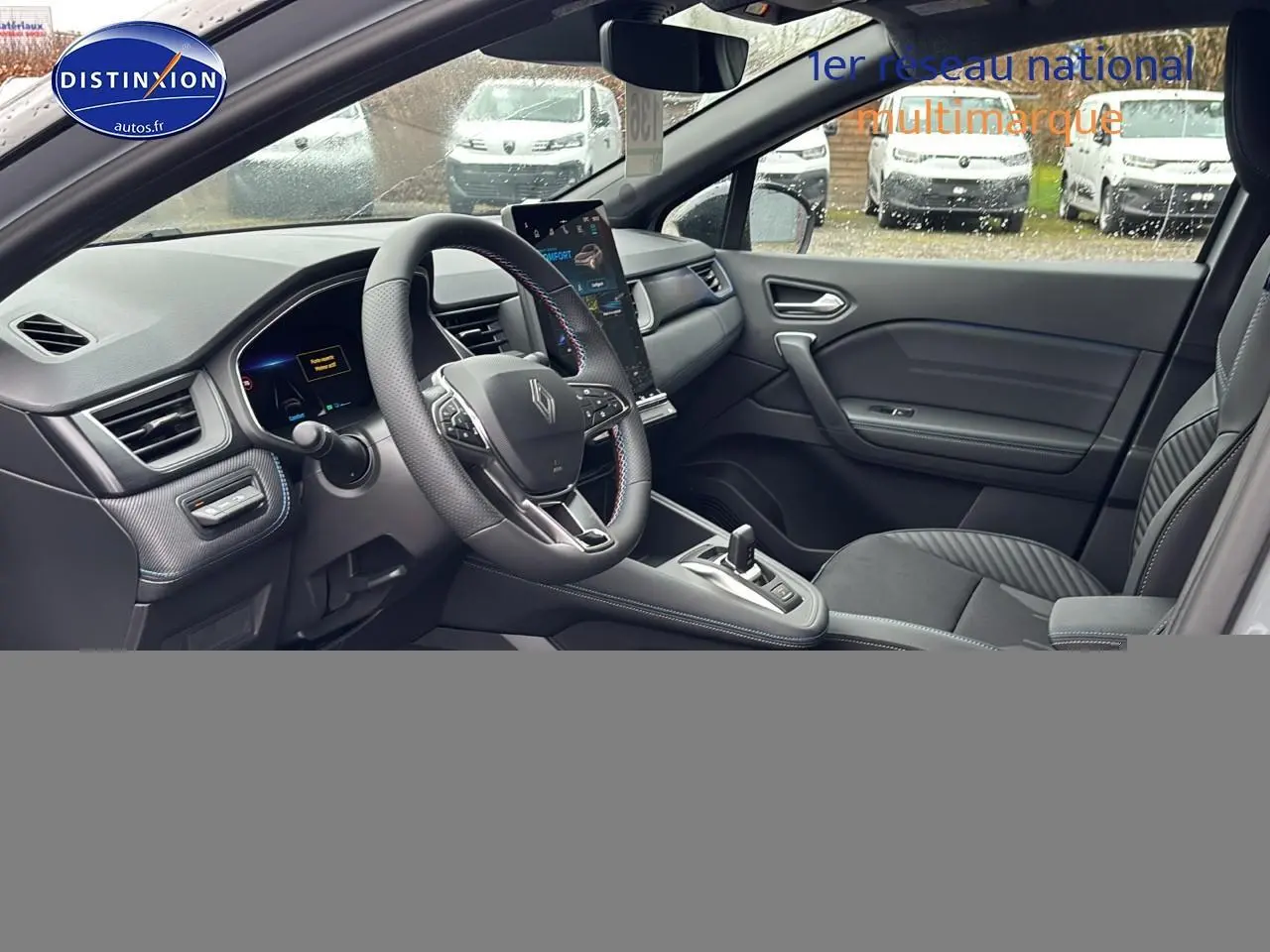 Intérieur avant droit du Renault Captur gris rafale, volant cuir multifonction et écran tactile vertical visible.