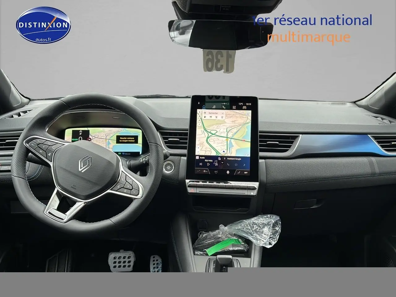 Vue intérieure avant du Renault Captur 2025 hybride, tableau de bord avec écran tactile vertical et volant multifonction cuir noir.