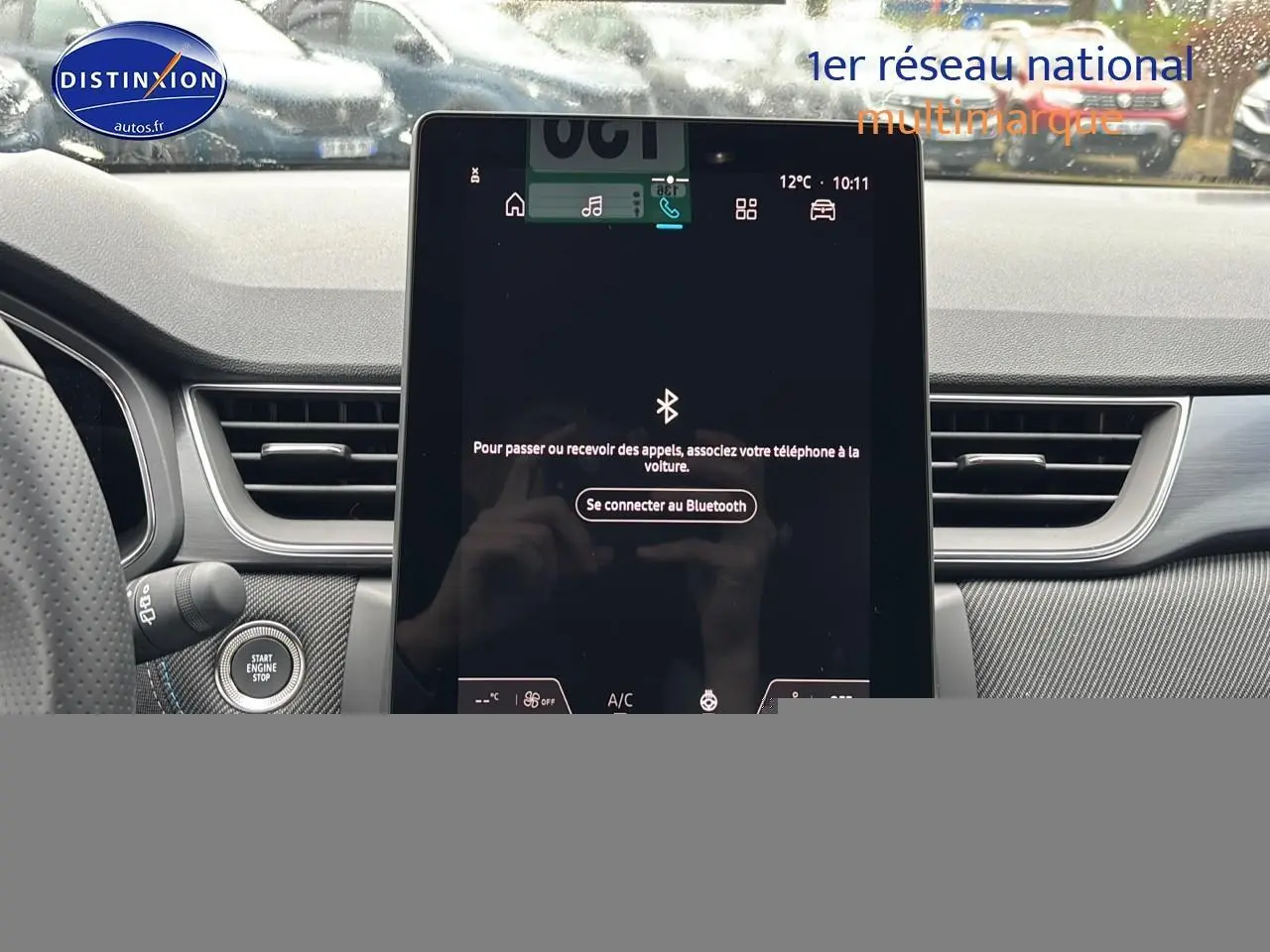 Vue intérieure centrée sur l'écran tactile du tableau de bord du Renault Captur gris rafale, avec bouton start visible.